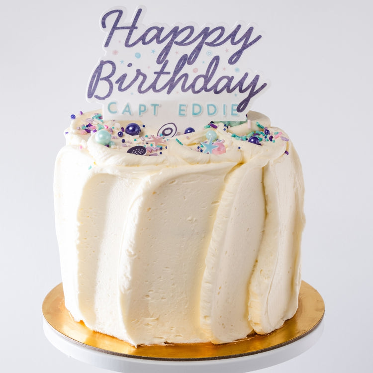 6-inch French vanilla cake with white buttercream frosting, colorful sprinkles, and a Happy Birthday Capt Eddie topper.